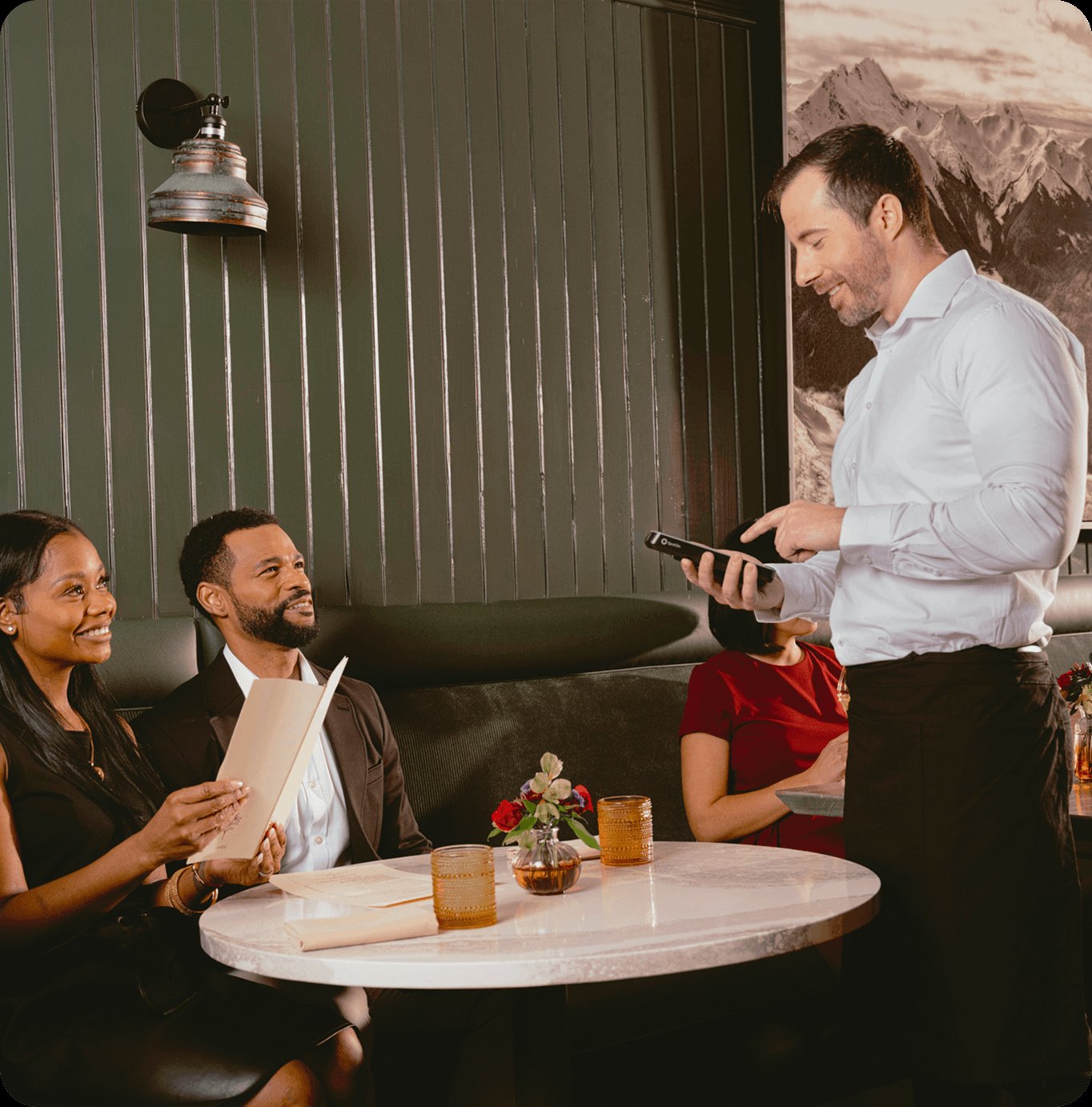 Server taking a tableside order on the current SpotOn Handheld